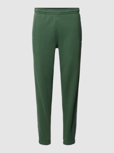 Lacoste Sweatpants mit Label-Streifen Modell 'TAPE' in Gruen, Größe M